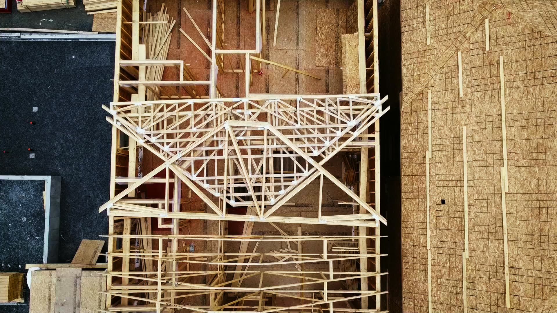 Vue aérienne de la charpente d’un bâtiment en cours de construction.