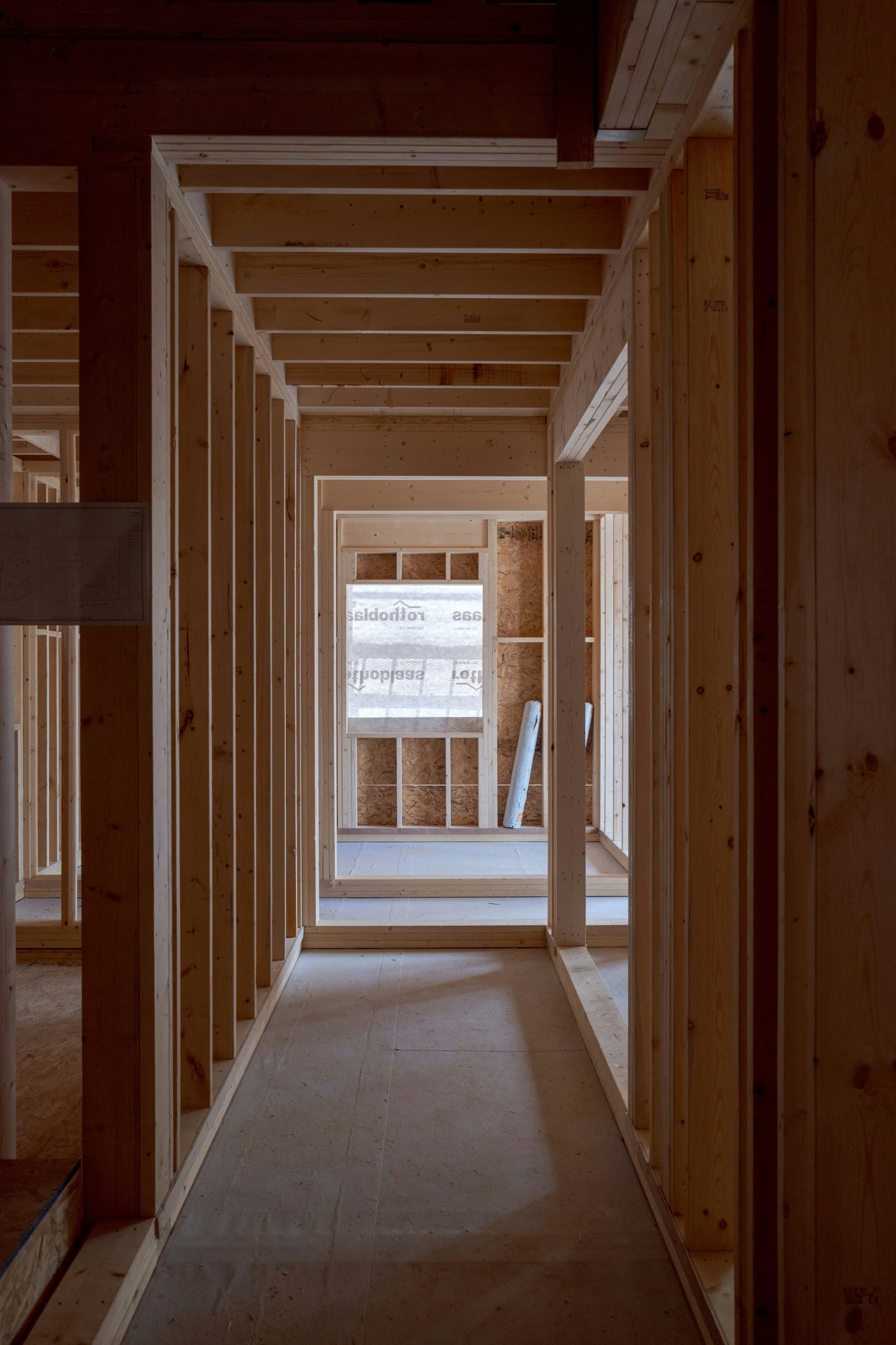 Enfilade de cloisons de bois alignées à l’intérieur d’un bâtiment en construction.